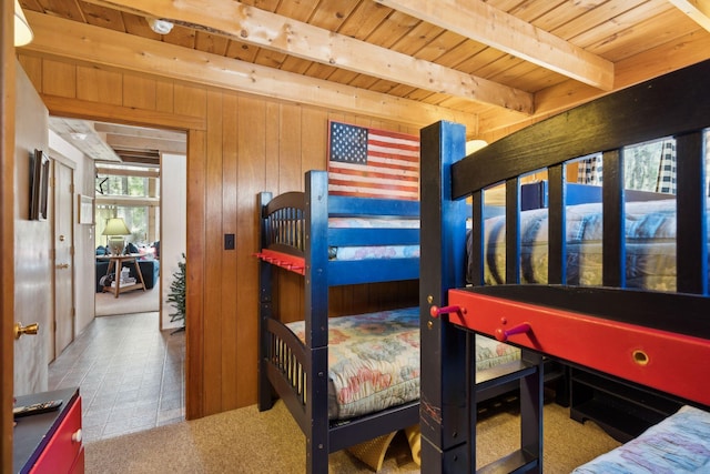 bedroom with wood ceiling, wood walls, carpet, and beam ceiling