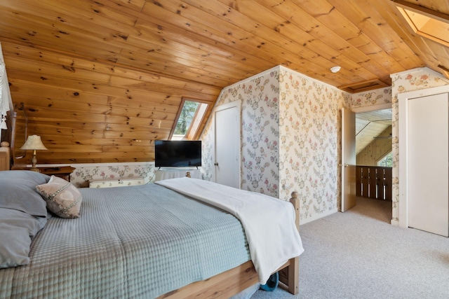 carpeted bedroom with vaulted ceiling with skylight, wooden ceiling, and multiple windows