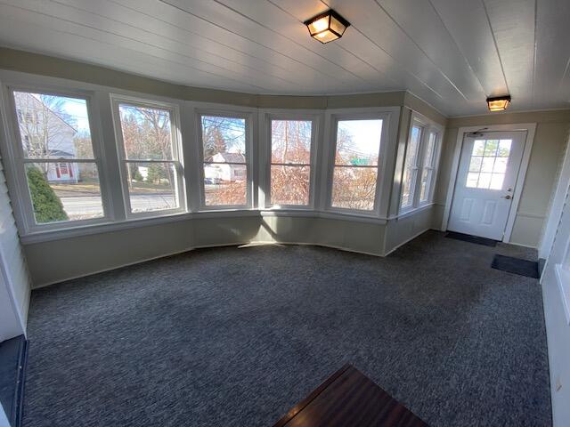 unfurnished room with dark colored carpet