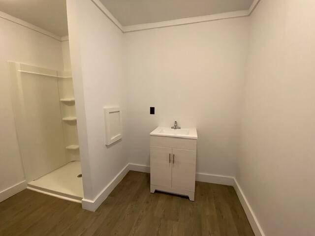 bathroom featuring hardwood / wood-style flooring, vanity, and a shower