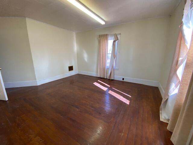 empty room featuring dark wood-type flooring