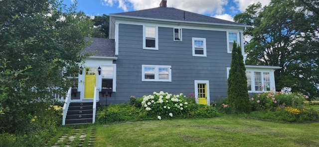 rear view of property with a lawn