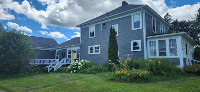 rear view of property featuring a lawn