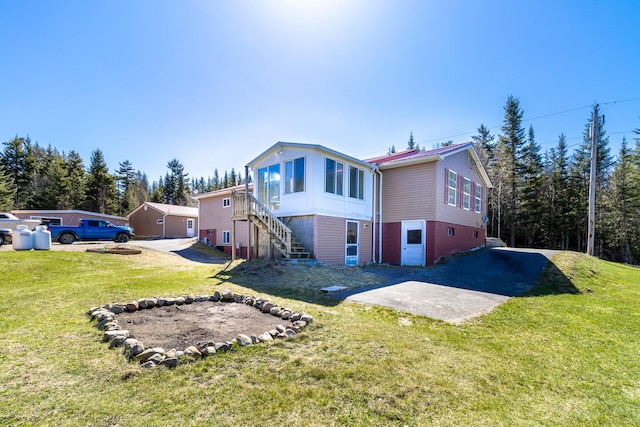 rear view of property with a lawn and a garage