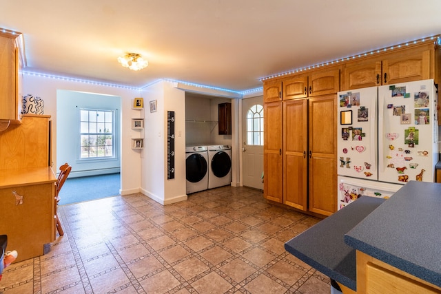 kitchen with a baseboard heating unit, white fridge, washing machine and clothes dryer, and light tile floors