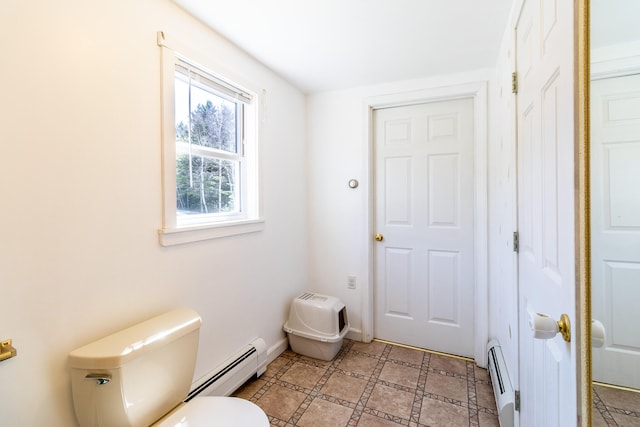 bathroom featuring tile flooring, toilet, and a baseboard heating unit