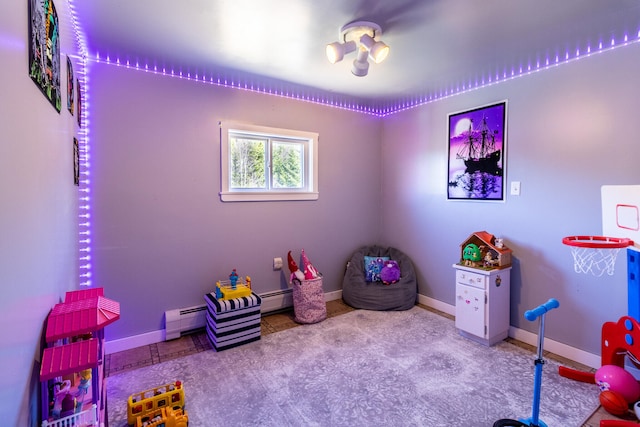 recreation room featuring light tile floors and a baseboard heating unit