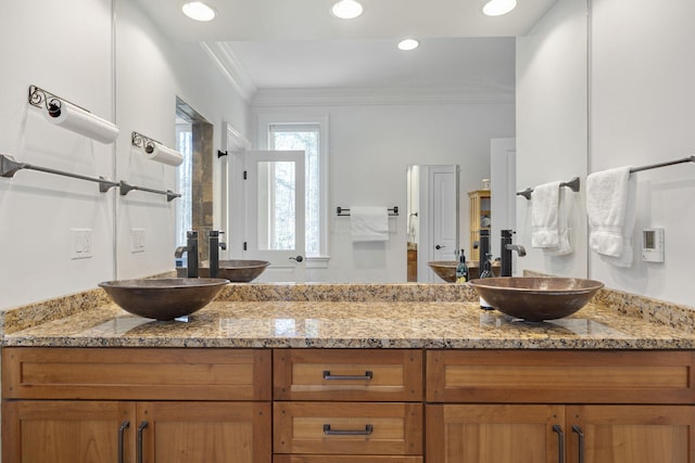 bathroom with vanity, a shower with door, and ornamental molding