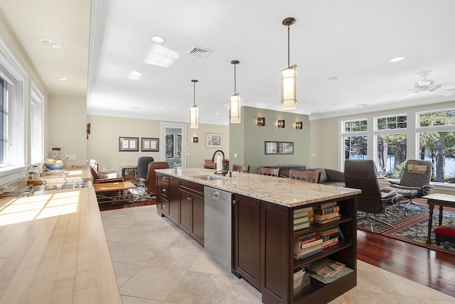 kitchen featuring dishwasher, light stone countertops, sink, and decorative light fixtures