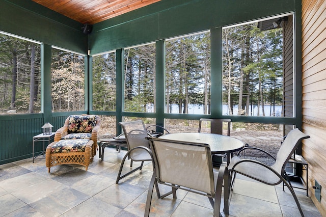 sunroom with a water view and wood ceiling