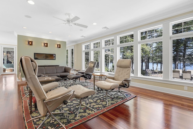 living room with hardwood / wood-style flooring, crown molding, and ceiling fan