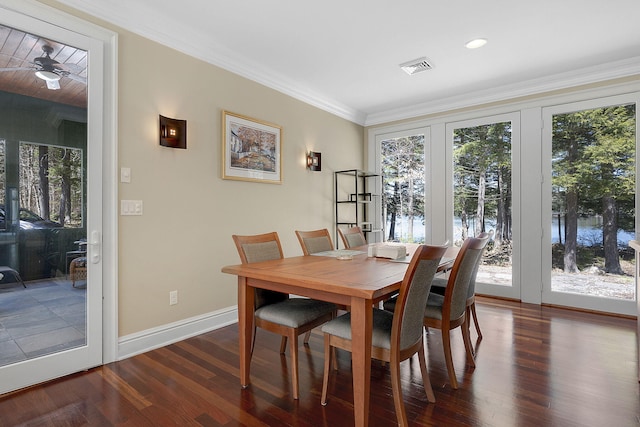 dining space featuring dark hardwood / wood-style flooring, crown molding, and a wealth of natural light