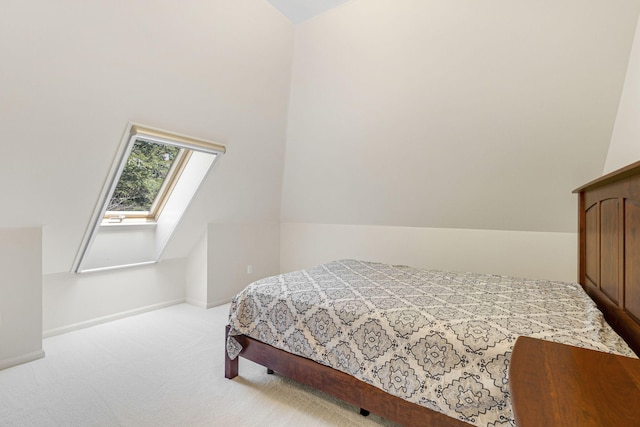 bedroom with lofted ceiling with skylight and light carpet