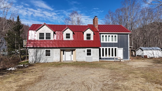 rear view of house featuring an outdoor structure