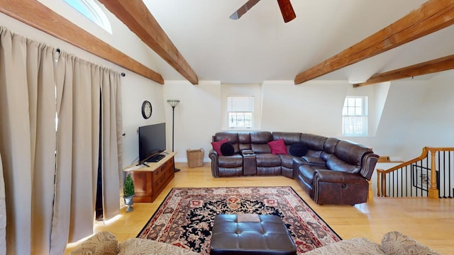 living room with beamed ceiling, ceiling fan, and light wood-type flooring