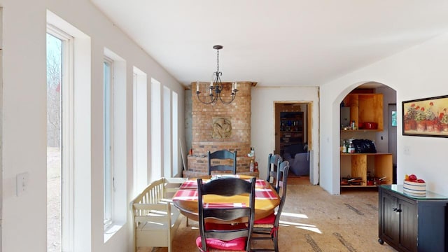 dining room with an inviting chandelier and brick wall