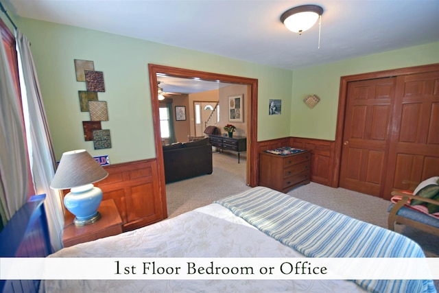 bedroom featuring a closet, light colored carpet, and wooden walls