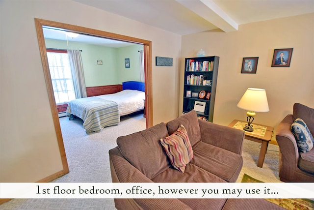 bedroom with beam ceiling, baseboard heating, and light carpet