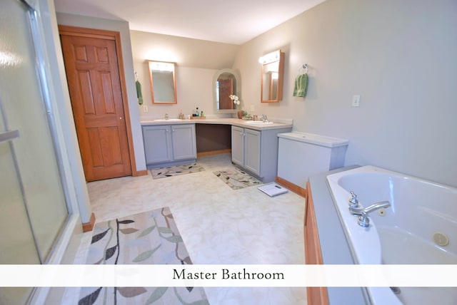 bathroom featuring a bathing tub, lofted ceiling, and vanity