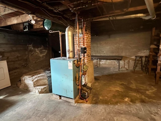 basement with brick wall and washer / dryer
