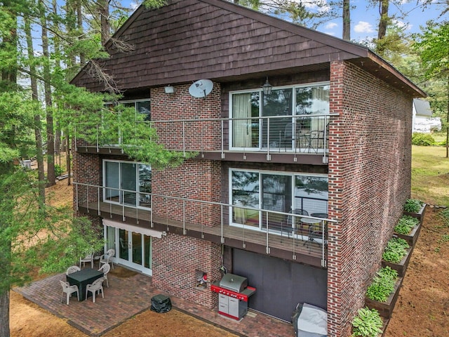 rear view of house featuring a balcony and a patio