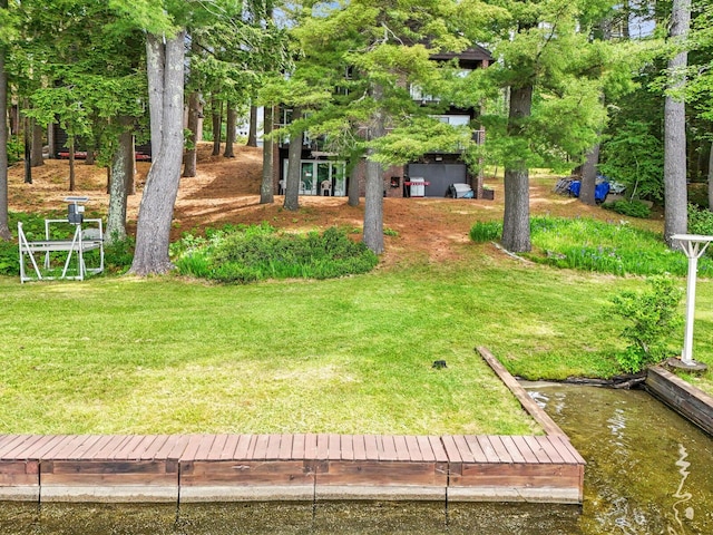 view of yard with a boat dock and a water view