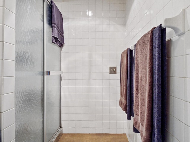 bathroom with an enclosed shower and tile walls