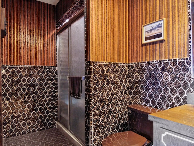 bathroom featuring toilet and tile walls