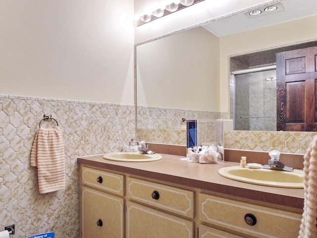 bathroom featuring a shower with shower door and vanity