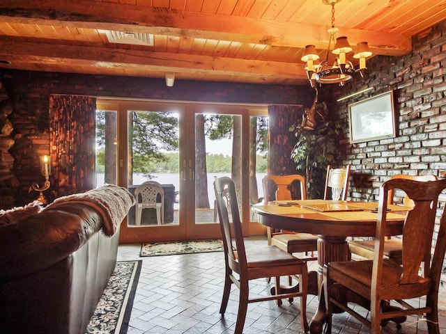 dining room with a notable chandelier, wooden ceiling, french doors, and beamed ceiling