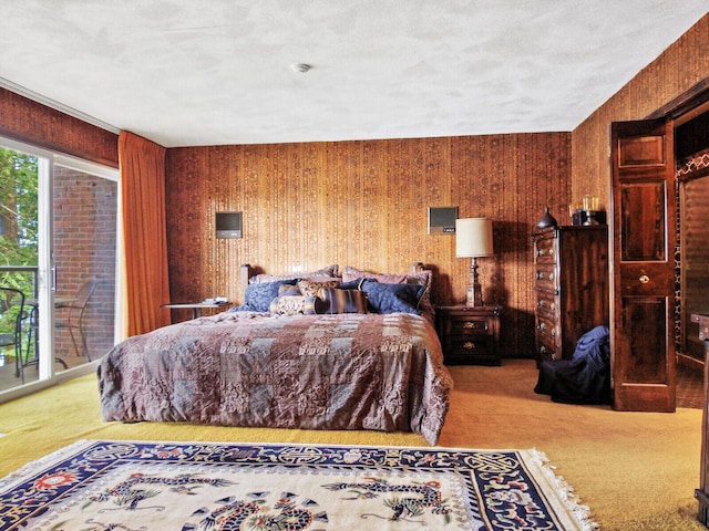 bedroom featuring access to exterior, wood walls, and carpet flooring