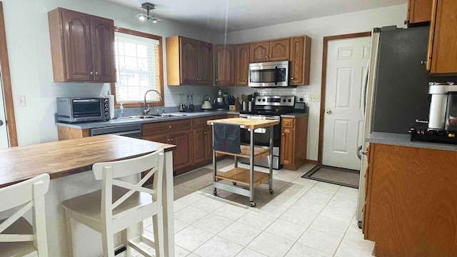 kitchen with sink, stainless steel appliances, light tile flooring, and tasteful backsplash