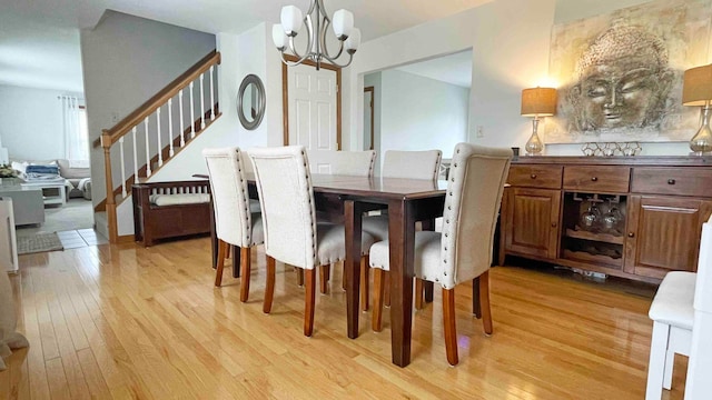 dining space with an inviting chandelier and light hardwood / wood-style floors