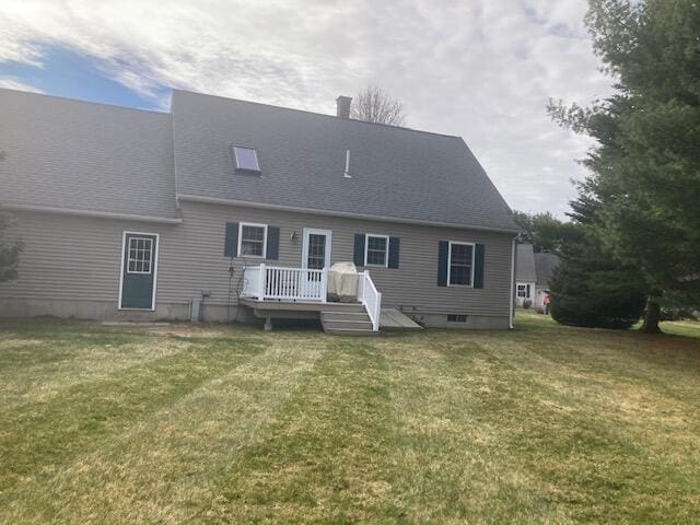 rear view of house featuring a deck and a lawn