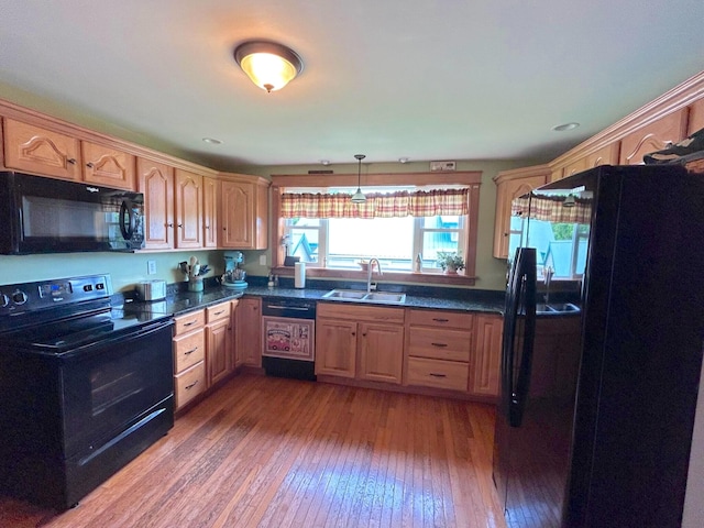 kitchen with hanging light fixtures, sink, hardwood / wood-style flooring, and black appliances