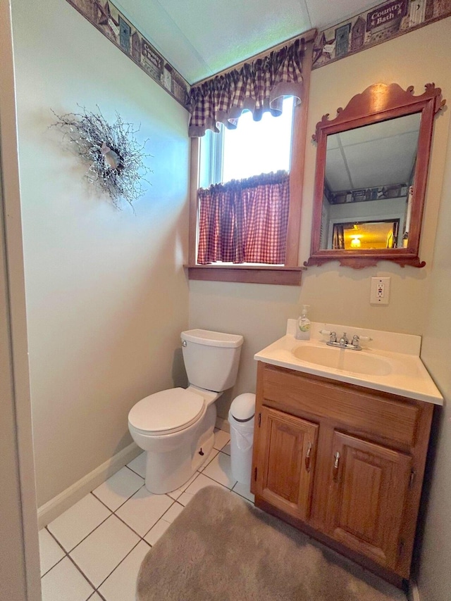 bathroom featuring toilet, tile floors, and vanity