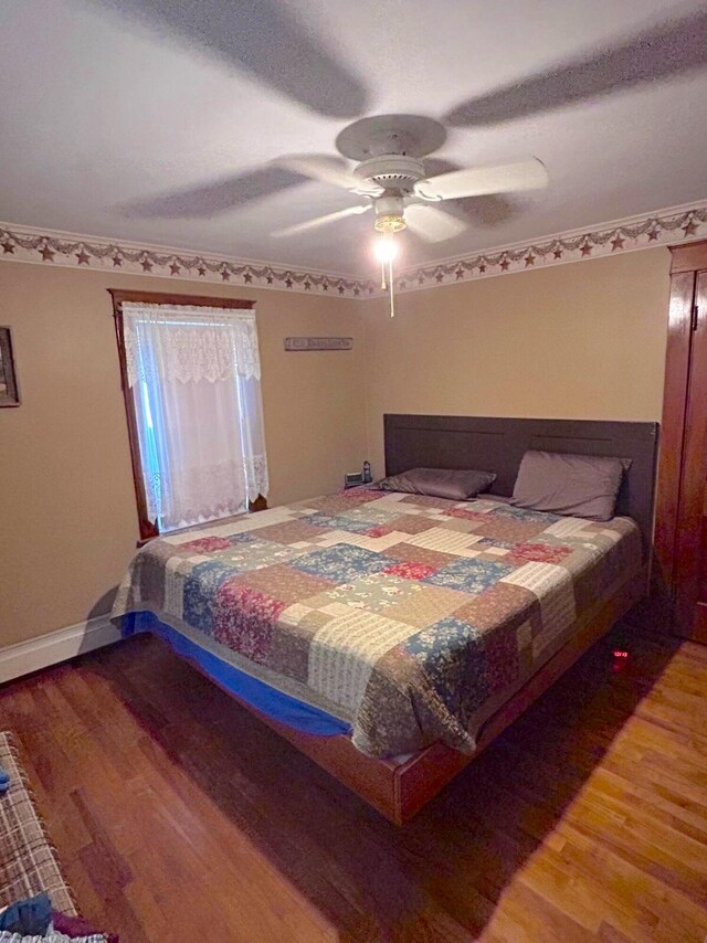 bedroom with ceiling fan and hardwood / wood-style flooring