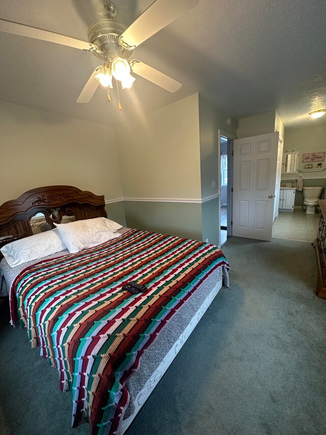 carpeted bedroom featuring connected bathroom, ceiling fan, and a textured ceiling