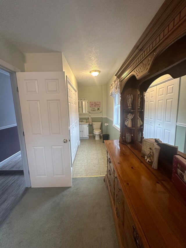 hallway featuring a textured ceiling and carpet floors