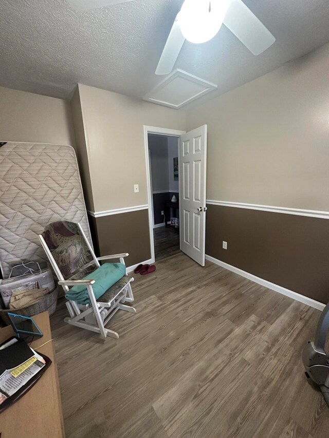 sitting room featuring a textured ceiling, ceiling fan, and hardwood / wood-style floors