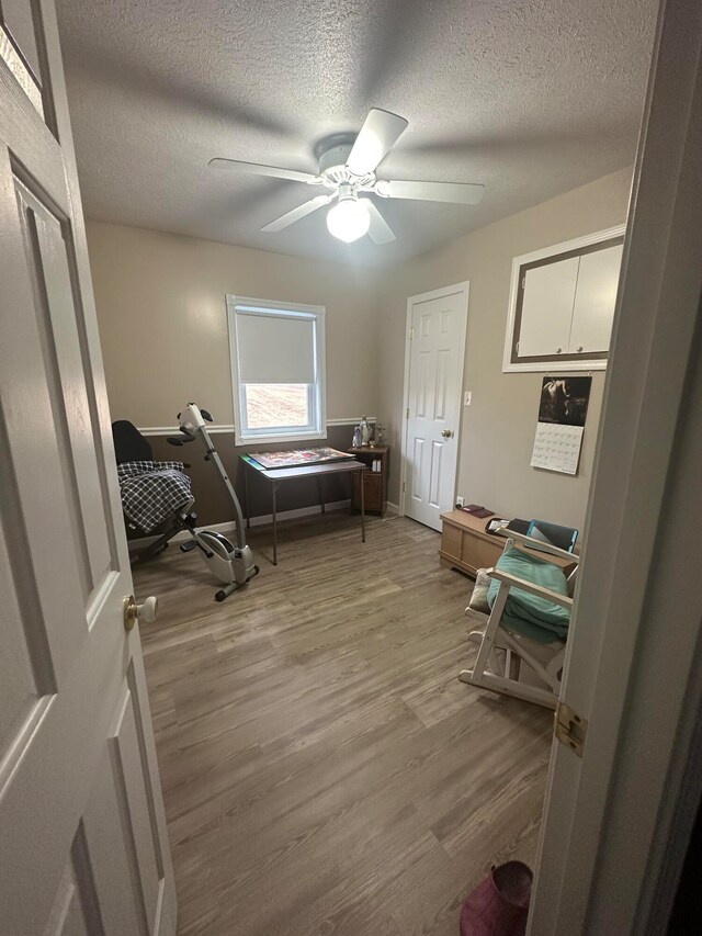 interior space featuring a textured ceiling, ceiling fan, and hardwood / wood-style floors