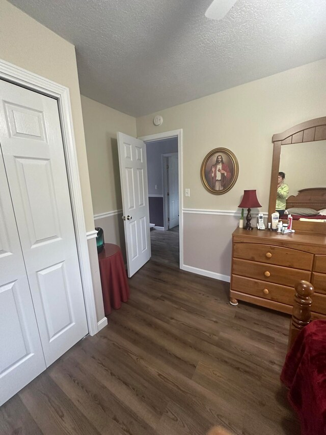 bedroom featuring a closet, a textured ceiling, and dark wood-type flooring