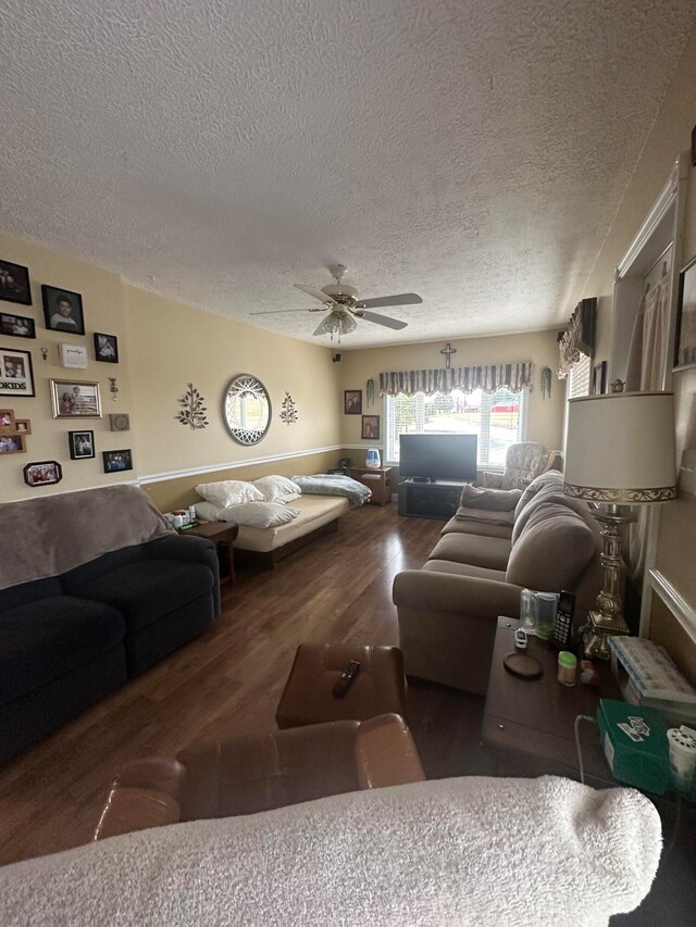 living room with a textured ceiling, hardwood / wood-style floors, and ceiling fan