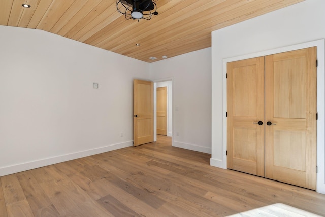 unfurnished bedroom with wood ceiling, light hardwood / wood-style floors, and a closet