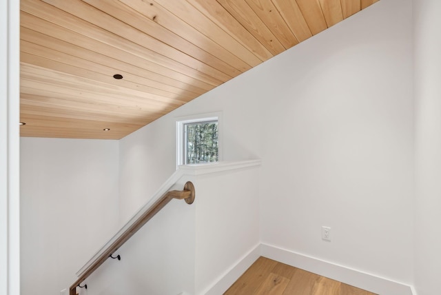 staircase featuring vaulted ceiling, wood-type flooring, and wooden ceiling