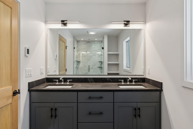 bathroom featuring a shower with door and vanity