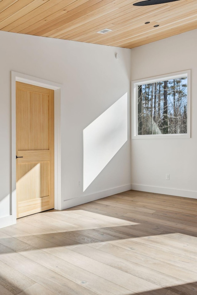 unfurnished room with wood ceiling and light hardwood / wood-style floors