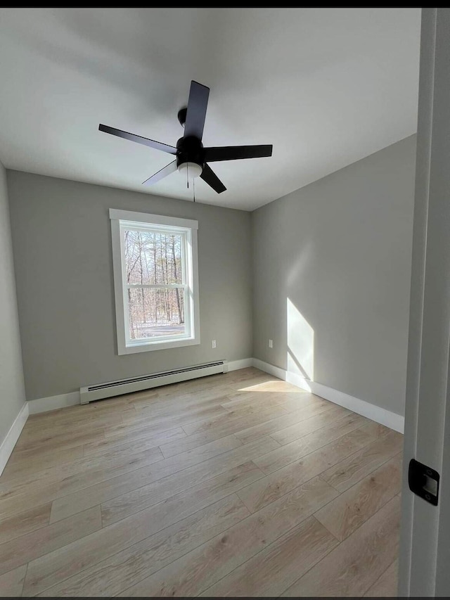 empty room featuring a baseboard radiator, ceiling fan, and light hardwood / wood-style floors