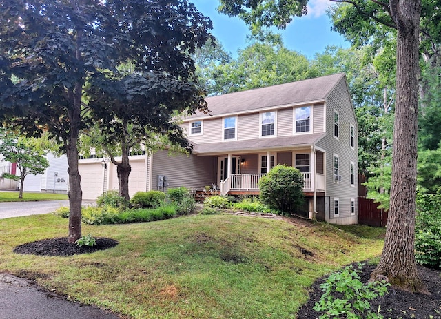 view of front of home featuring a garage, covered porch, and a front yard