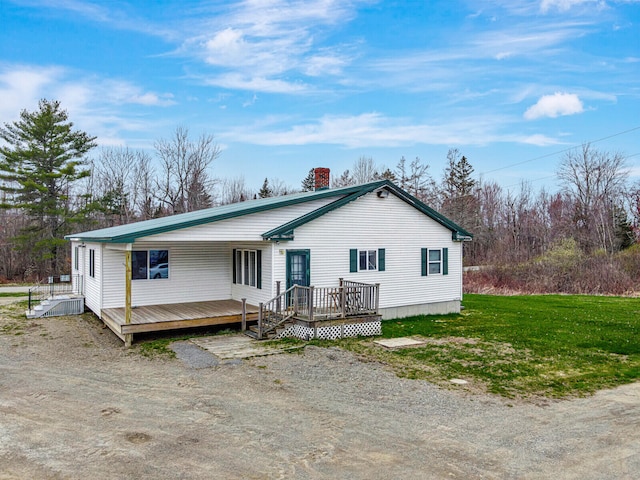 view of front of property with a deck and a front lawn